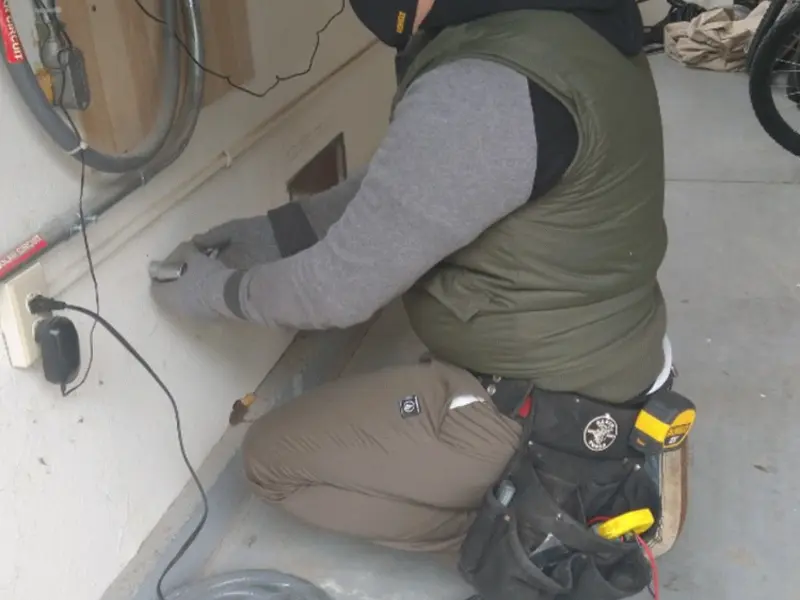 Electrician performing outlet wiring in a Aldan garage